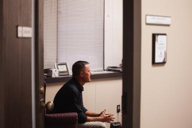 从他的门外望去，可以看到Myron Parsley坐在他的办公室里，就像他和一个学生一起工作一样. 帕斯利是澳门体育赌博十大平台咨询中心的心理健康咨询师, 为克里特岛校区的学生服务. 